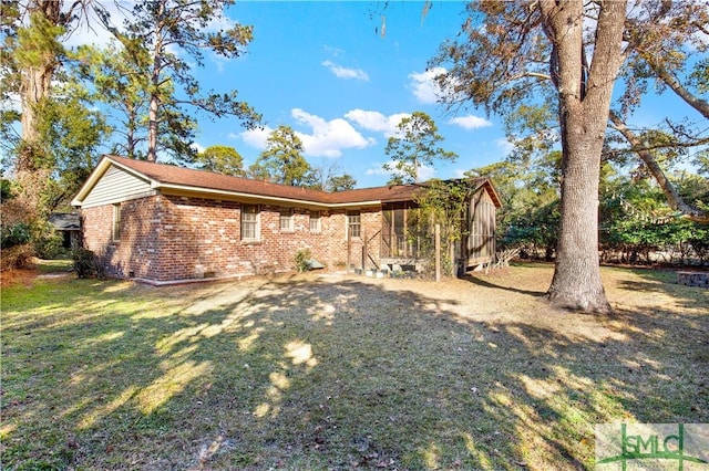 back of house featuring crawl space, a lawn, and brick siding