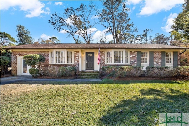 ranch-style house featuring driveway, brick siding, crawl space, and a front yard