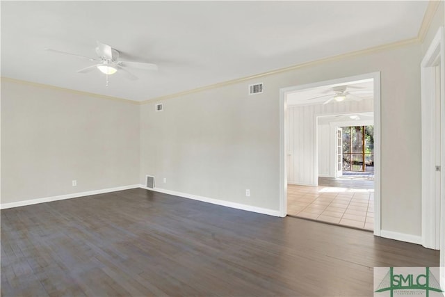 spare room featuring ornamental molding, dark wood-type flooring, visible vents, and a ceiling fan