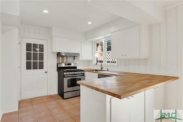 kitchen with sink, stainless steel gas stove, extractor fan, white cabinets, and kitchen peninsula