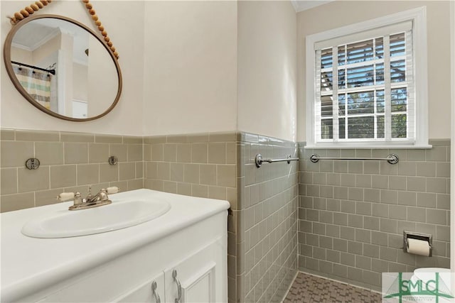 bathroom with vanity, a shower with shower curtain, and tile walls