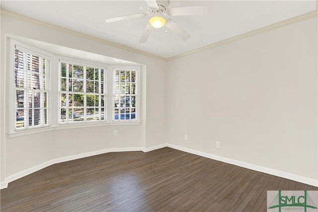 empty room with dark wood-style floors, baseboards, and ornamental molding