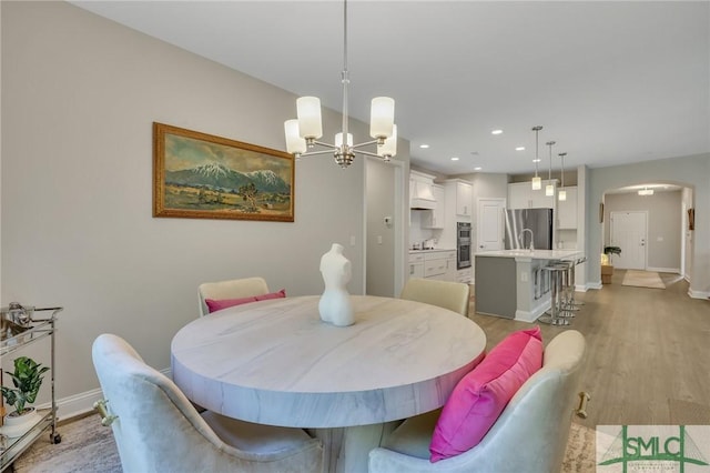 dining space with a chandelier and light wood-type flooring