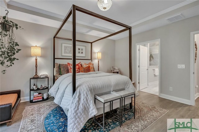 bedroom with hardwood / wood-style floors, ensuite bath, and ornamental molding