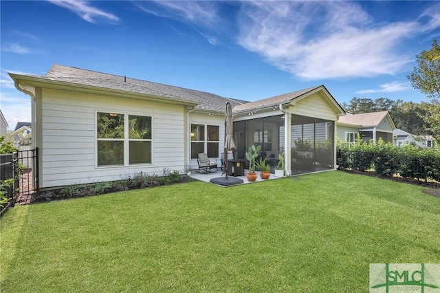 rear view of house with a patio area, a sunroom, and a lawn