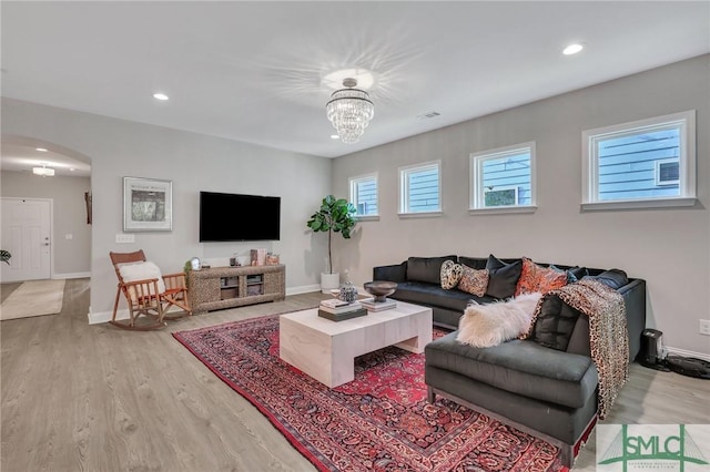 living room featuring a chandelier and light hardwood / wood-style flooring