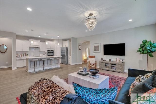 living room with light hardwood / wood-style floors and a chandelier