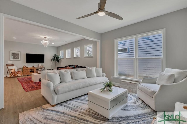 living room featuring wood-type flooring and ceiling fan