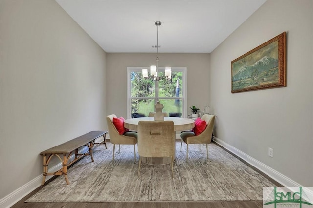 dining space featuring wood-type flooring and a chandelier