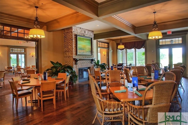 dining area featuring hardwood / wood-style floors, beam ceiling, coffered ceiling, ornamental molding, and a brick fireplace