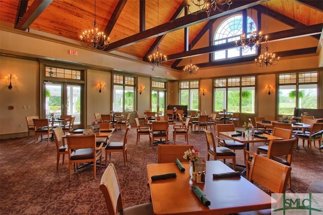 dining room featuring beamed ceiling, a healthy amount of sunlight, a chandelier, and wooden ceiling