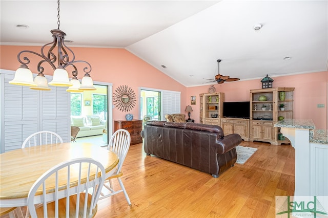 living room with ceiling fan with notable chandelier, lofted ceiling, light hardwood / wood-style flooring, and ornamental molding