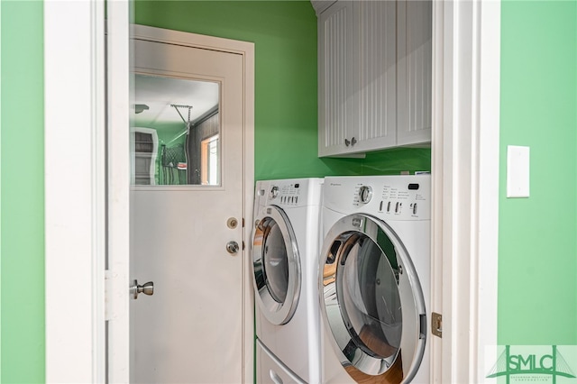 washroom featuring cabinets and washing machine and dryer