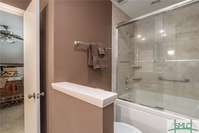 bathroom with ceiling fan, shower / bath combination with glass door, and toilet