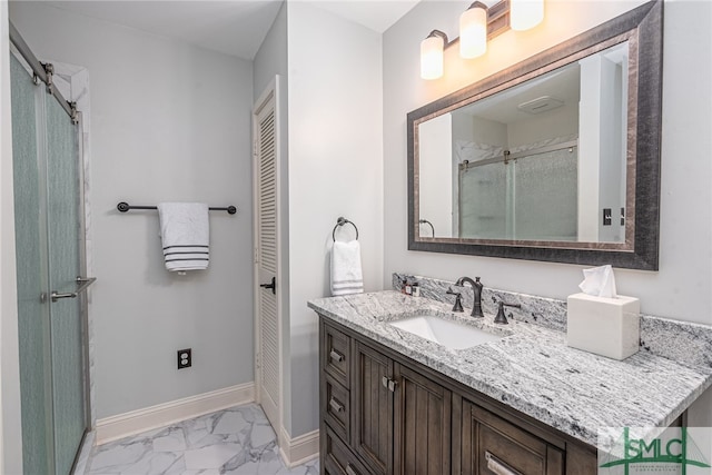 bathroom featuring a shower with shower door and vanity