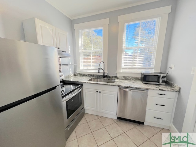 kitchen featuring white cabinets, ornamental molding, sink, stainless steel appliances, and range hood