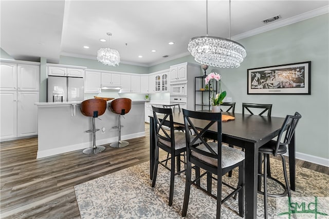 dining area with an inviting chandelier, crown molding, and dark hardwood / wood-style flooring