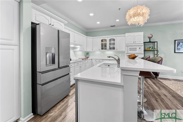 kitchen featuring a center island with sink, pendant lighting, light wood-type flooring, stainless steel refrigerator with ice dispenser, and sink