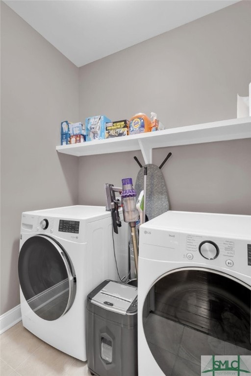 laundry area with separate washer and dryer and light tile patterned floors