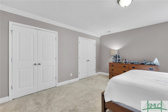 carpeted bedroom featuring two closets