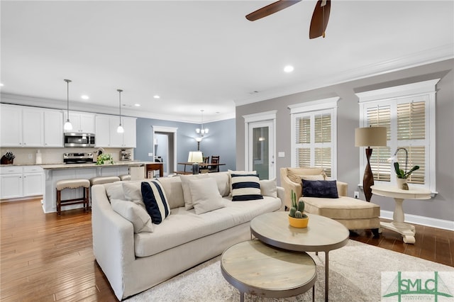 living room featuring hardwood / wood-style flooring, ceiling fan, and ornamental molding