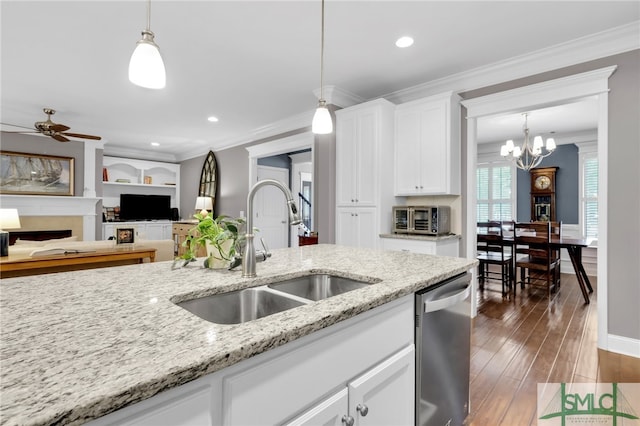 kitchen featuring sink, light stone counters, dishwasher, pendant lighting, and white cabinets