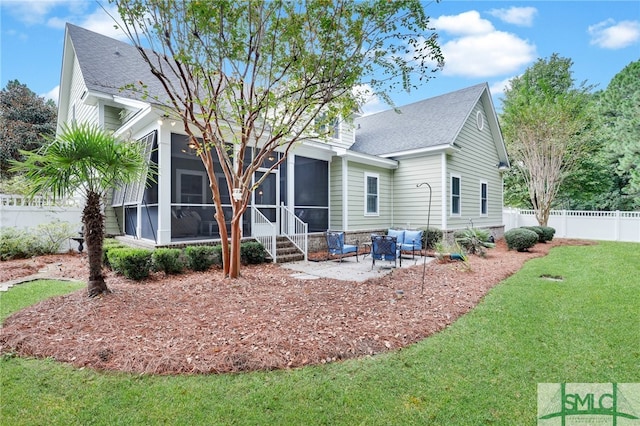 back of house with a patio area, a sunroom, and a lawn