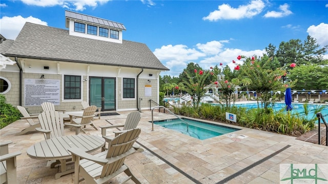 view of swimming pool featuring a patio area and a hot tub