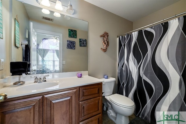 bathroom featuring vanity, tile patterned flooring, and toilet