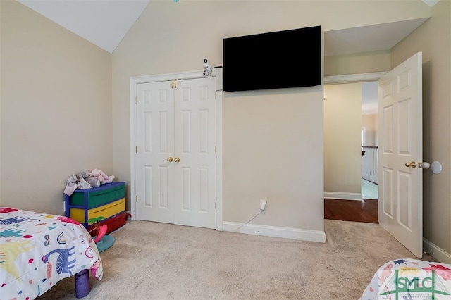 carpeted bedroom featuring lofted ceiling and a closet