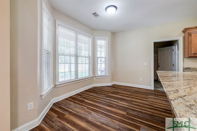 unfurnished dining area featuring dark hardwood / wood-style floors