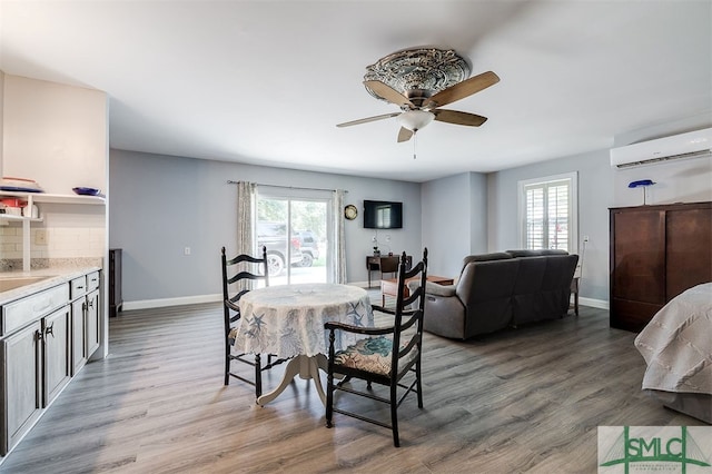 dining room with a wall unit AC, ceiling fan, and dark hardwood / wood-style floors