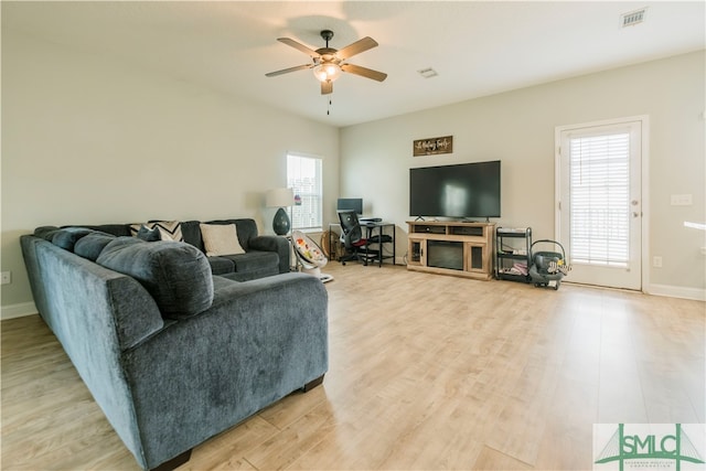 living room with light wood-type flooring and ceiling fan