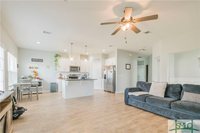 living room featuring ceiling fan and light hardwood / wood-style flooring