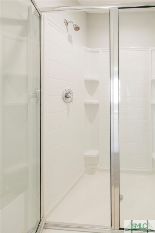 bathroom featuring a shower with shower door