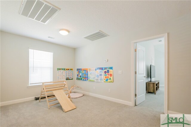 living area with light carpet and a textured ceiling