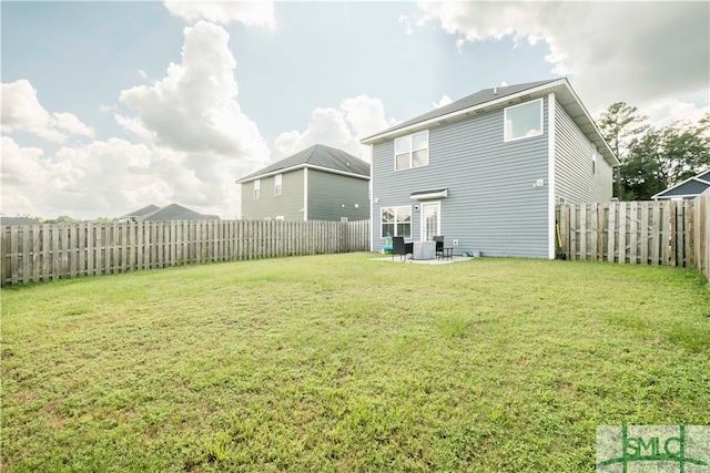 back of house with a lawn and a patio