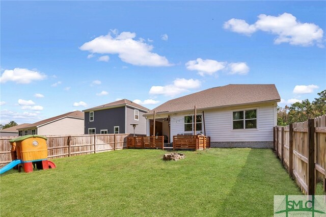 rear view of property featuring a lawn