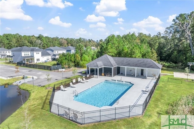 view of pool featuring a lawn, a water view, and a patio area