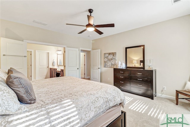 bedroom featuring ceiling fan, ensuite bath, and light carpet