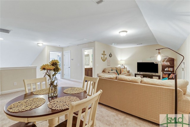 dining space with lofted ceiling and light carpet