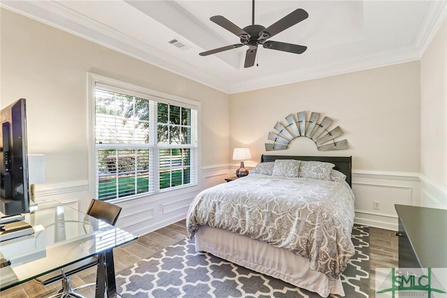 bedroom with ornamental molding, hardwood / wood-style floors, and ceiling fan