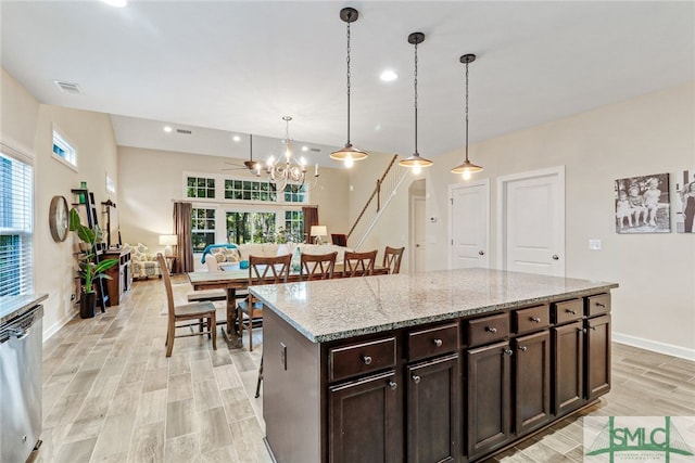 kitchen with stainless steel dishwasher, dark brown cabinets, pendant lighting, and light hardwood / wood-style flooring