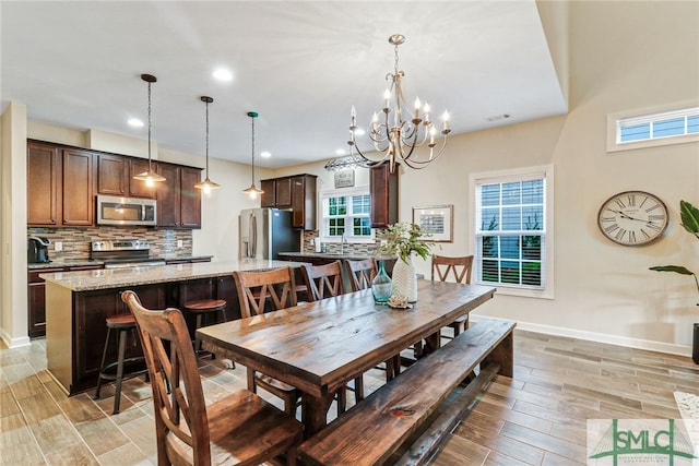 dining area with an inviting chandelier, a wealth of natural light, and light hardwood / wood-style floors