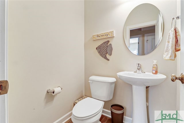 bathroom featuring wood-type flooring and toilet