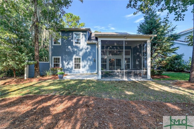 back of house with a patio, a yard, and a sunroom