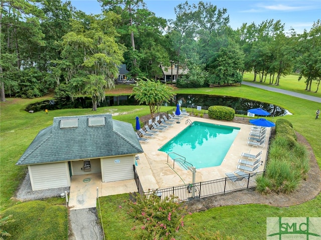 view of swimming pool with a water view, a patio area, and a yard