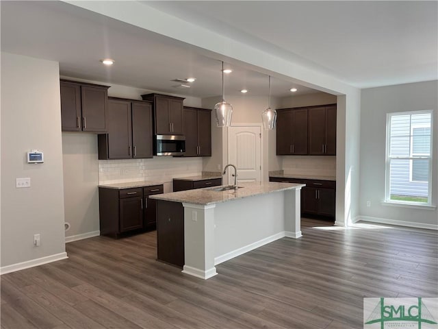 244 Brookline Dr, Savannah, GA 31407 - kitchen with a sink, dark brown cabinetry, stainless steel microwave, and an island with sink