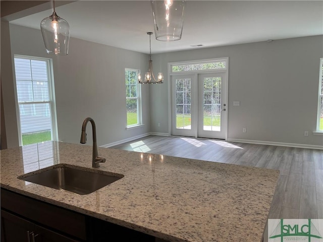 244 Brookline Dr, Savannah, GA 31407 - kitchen featuring baseboards, hanging light fixtures, a sink, light stone counters, and light wood finished floors