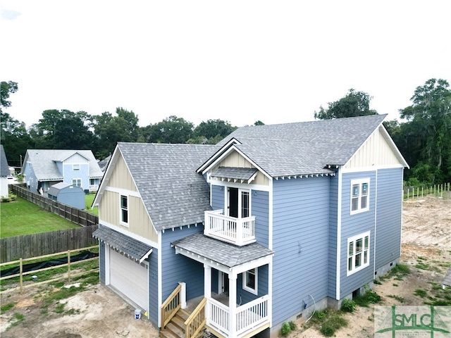 back of house featuring a balcony and a garage